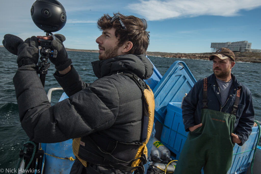 Théo Belnou realizando una captura de vídeo 360° sobre una embarcación en mar abierto con una cámara profesional, durante una producción inmersiva en Fogo Island.