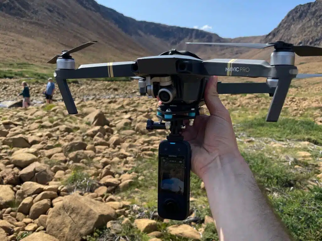 Drone DJI Mavic Pro équipé d'une caméra 360 degrés Insta360 One suspendue en dessous, prêt à décoller dans un environnement naturel.