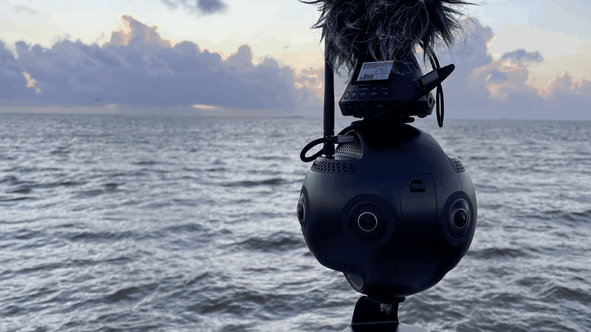 Caméra 360 haute résolution montée sur un trépied face à la mer pour une production de vidéo 360 immersive.