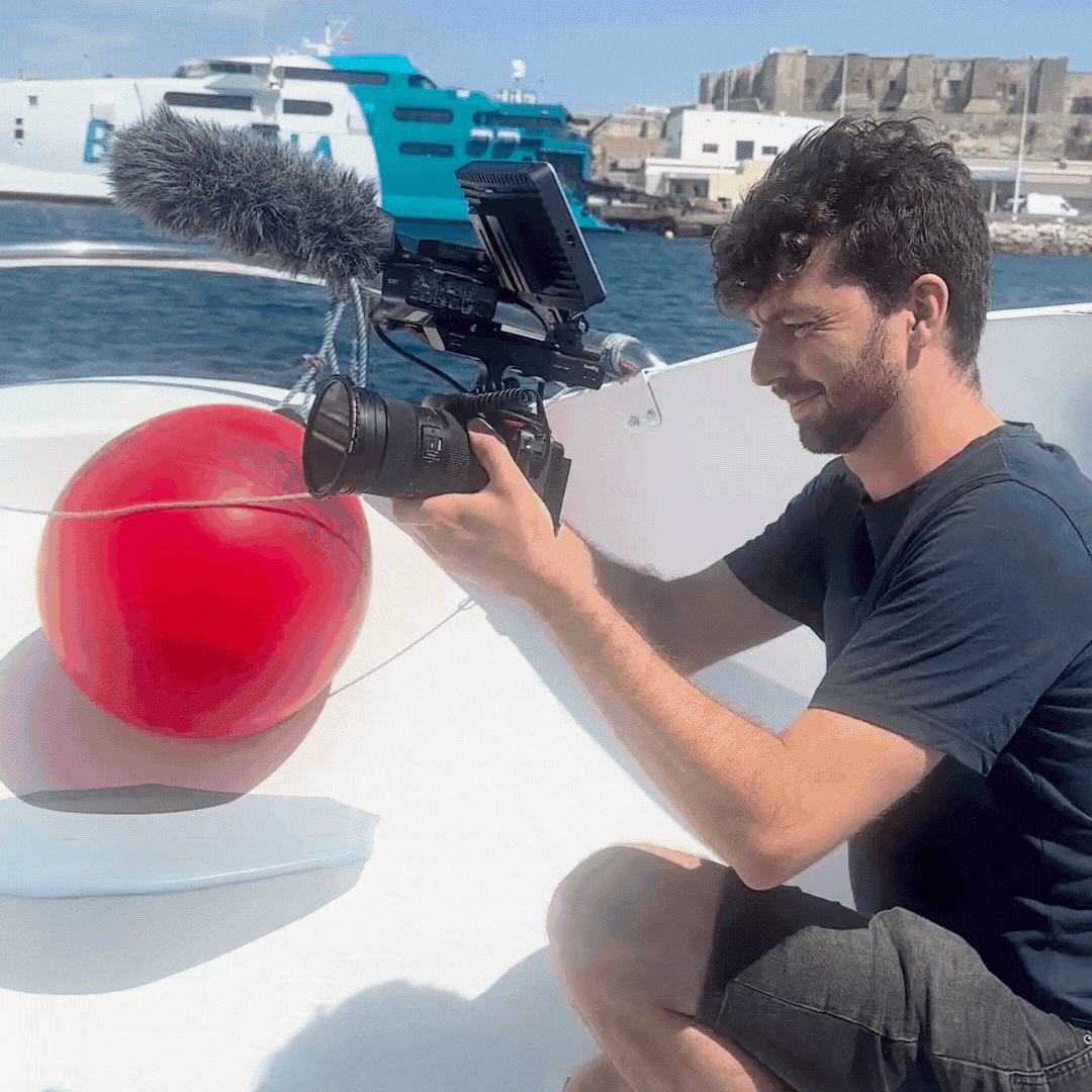 Théo Belnou grabando con teleobjetivo y micrófono direccional durante la producción de un documental en el mar.